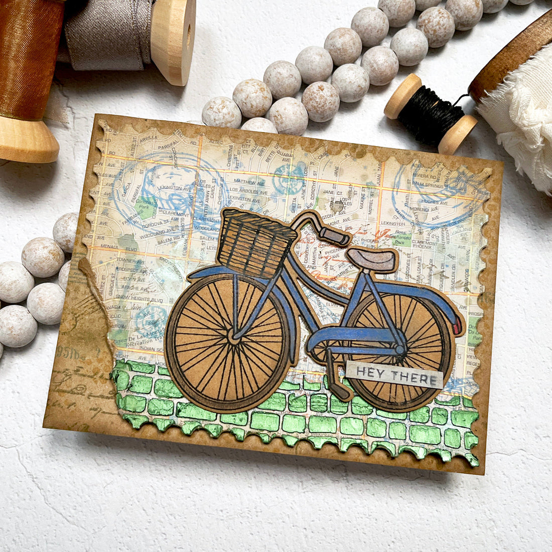 Mixed Media card featuring a bike and travel theme map background.